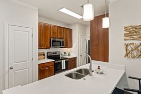 Raleigh apartment for rent - A kitchen with a white counter top and wooden cabinets.