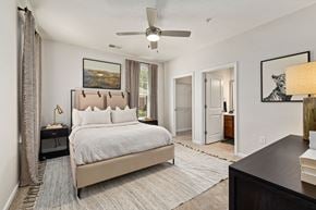 Raleigh apartment for rent - A bedroom with a large bed and a ceiling fan.