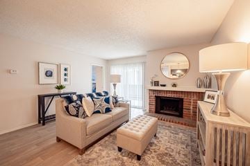 San Antonio apartment for rent - A living room with a couch, a fireplace, and a painting on the wall.