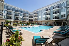 Alpharetta apartment for rent - an apartment building with a swimming pool and lounge chairs
