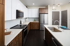 Alpharetta apartment for rent - a large kitchen with white counter tops and wooden cabinets