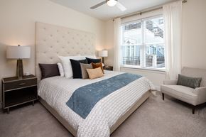 Alpharetta apartment for rent - a bedroom with a bed and a chair and a window