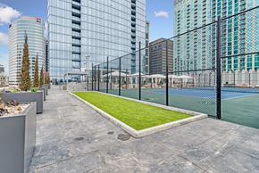 Nashville apartment for rent - A tennis court surrounded by a fence and buildings.