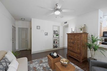 San Antonio apartment for rent - A living room with a white couch, a wooden cabinet, and a rug on the floor.