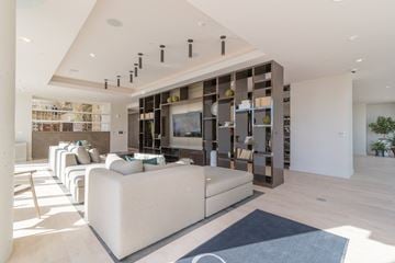 Nashville apartment for rent - A modern living room with a white sofa and a wooden cabinet.