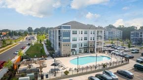 Charlotte apartment for rent - an aerial view of a building with a pool and parking lot