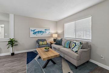 Phoenix apartment for rent - A living room with a grey couch, a wooden coffee table, and a painting of a fish on the wall.
