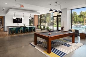 Atlanta apartment for rent - a pool table in a clubhouse with a bar and a swimming pool