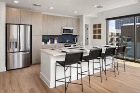 Atlanta apartment for rent - a kitchen with a large island with bar stools and a stainless steel refrigerator