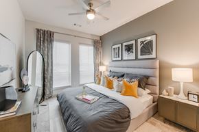Grapevine apartment for rent - a bedroom with a large bed and a ceiling fan