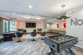 North Bethesda apartment for rent - A foosball table is in the middle of a room with a pool table and a couch.