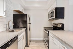 Phoenix apartment for rent - A black refrigerator stands next to a sink in a kitchen.