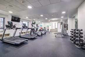 Seattle apartment for rent - a gym with treadmills and other exercise equipment in a building with windows