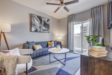 Salt Lake City apartment for rent - a living room with a blue couch and a ceiling fan