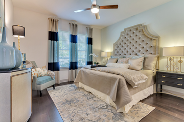 Dallas apartment for rent - A bedroom with a large bed and a ceiling fan.