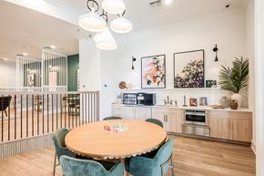 Maitland apartment for rent - A kitchen with a table and chairs in the foreground and a woman standing in the background.