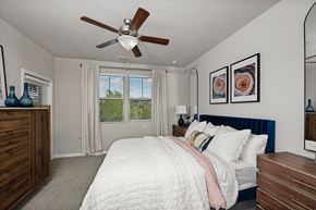 Orlando apartment for rent - A bedroom with a bed, dresser, and ceiling fan.