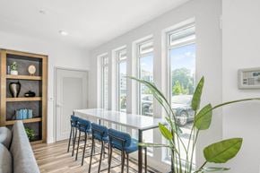 Charlotte apartment for rent - a dining room with white walls and a long white table with blue chairs