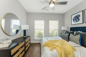 Charlotte apartment for rent - a bedroom with a ceiling fan and two windows