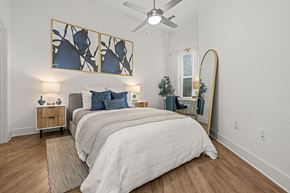 Charlotte apartment for rent - A bedroom with a large bed and a ceiling fan.