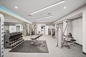 Evanston apartment for rent - A gym with a variety of equipment including a squat rack, a bench, and a weight machine.
