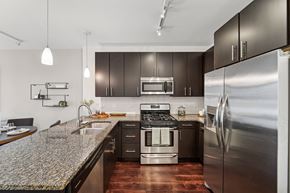 Evanston apartment for rent - A modern kitchen with dark brown cabinets and stainless steel appliances.