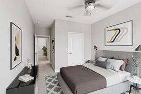 The Woodlands apartment for rent - A bedroom with a large bed and a ceiling fan.
