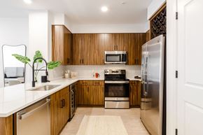 Harrison apartment for rent - a kitchen with wooden cabinets and stainless steel appliances at Dey & Bergen, New Jersey, 07029