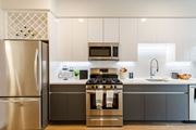 Jersey City apartment for rent - a kitchen with stainless steel appliances and white cabinets at One Ten Apartments, Jersey City