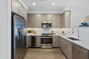 Pearl River apartment for rent - A modern kitchen with a stainless steel refrigerator and a microwave above the stove at The Reserve at Pearl River Apartments, Pearl River, NY