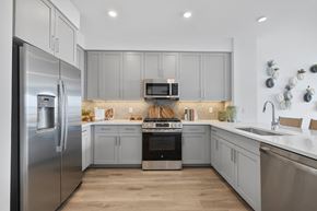South Amboy apartment for rent - A modern kitchen with a stainless steel refrigerator and wooden flooring.at The Pearl at Station Bay, South Amboy, NJ 08879