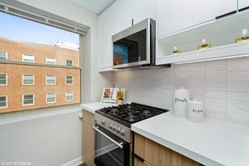 A kitchen with a stove top oven next to a window