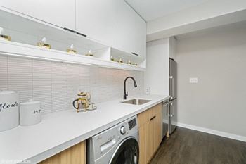 A laundry room with a washer and a sink