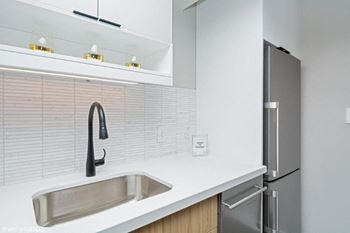A kitchen with a sink and a refrigerator
