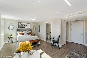 Washington apartment for rent - a bedroom with a large bed and a bathroom in the background at Carver and Slowe Apartments, Washington, Washington, DC 20001