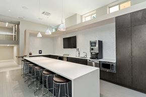 Washington apartment for rent - a kitchen with a long white counter and a row of stools in front of it at Carver and Slowe Apartments, Washington, DC, 20001