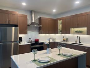 Alexandria apartment for rent - A modern kitchen with a stainless steel refrigerator and wooden cabinets at Essen Apartments, Alexandria, 22311