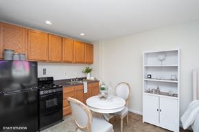 Washington apartment for rent - a kitchen with black appliances and a white table and chairs