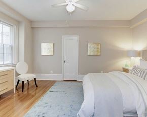 Washington apartment for rent - a bedroom with a bed and a chair in front of a window