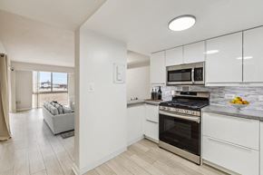 Washington apartment for rent - a kitchen with white cabinets and a stove and a microwave