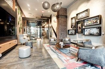 A lobby with couches and chairs and a glass door