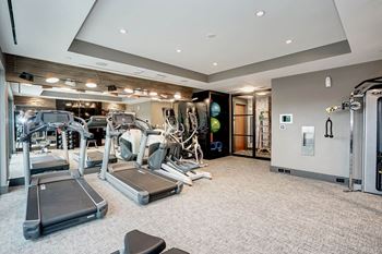 A gym with cardio equipment and weights on the floor