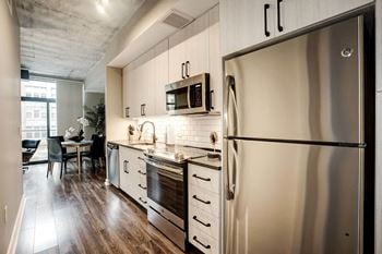 A kitchen with stainless steel appliances and white cabinets