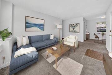 Silver Spring apartment for rent - A living room with a blue couch, a white chair, and a painting on the wall.
