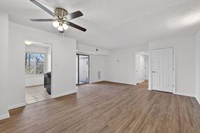 Washington apartment for rent - A room with a ceiling fan and wooden flooring.