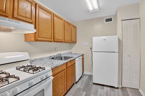 Landover apartment for rent - A kitchen with a white stove and wooden cabinets.