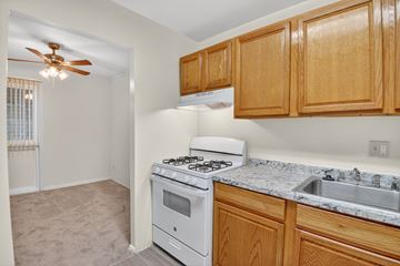 Landover apartment for rent - A kitchen with a white stove and wooden cabinets.