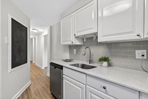 Washington apartment for rent - A kitchen with white cabinets and a blackboard on the wall.