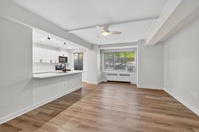 Washington apartment for rent - A spacious room with wooden flooring and a ceiling fan.