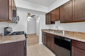 Washington apartment for rent - A kitchen with brown cabinets and a black dishwasher.